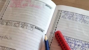 Hausaufgabenheft Grundschule mit Stiften