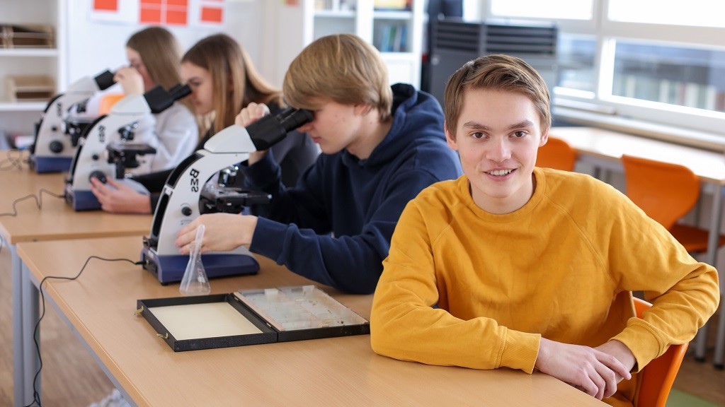 EmiLe Montessori mehrere Schüler am Mikroskop gespiegelt